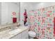 Bright bathroom featuring a vanity with granite countertops and colorful owl-themed shower curtain at 17055 W El Caminito Dr, Waddell, AZ 85355