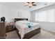 Bedroom with a large bed and a ceiling fan with neutral color walls at 17055 W El Caminito Dr, Waddell, AZ 85355