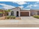 Charming single-story home with a well-manicured front yard and a two-car garage at 17055 W El Caminito Dr, Waddell, AZ 85355