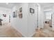 Bright hallway with neutral paint, carpet and tile flooring, and decorative wall art at 17055 W El Caminito Dr, Waddell, AZ 85355