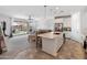 Open concept living space with a large kitchen island that overlooks the Gathering room and sliding door to patio at 17055 W El Caminito Dr, Waddell, AZ 85355