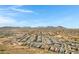 An elevated view highlights a community with uniform homes and winding streets against a mountain backdrop at 1743 W Flintlock Dr, San Tan Valley, AZ 85144