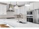 Bright kitchen featuring white cabinets, stainless steel appliances, and quartz countertops at 1743 W Flintlock Dr, San Tan Valley, AZ 85144