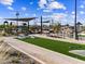 Cornhole boards at community park next to modern playgrounds, covered picnic tables, and landscaping at 17723 W Amber Dr, Goodyear, AZ 85338