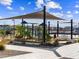 Playground with modern play structures and covered picnic tables under a shaded awning and ramada at 17723 W Amber Dr, Goodyear, AZ 85338