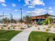 Sidewalk path leads through a playground with covered picnic tables in a community park at 17723 W Amber Dr, Goodyear, AZ 85338