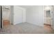 Bright bedroom with neutral carpet, double closet, and an ensuite bathroom at 18432 W Mohave St, Goodyear, AZ 85338
