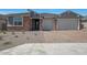 Charming single-story home with brick accents, a two-car garage, and a well-maintained desert landscaped front yard at 18432 W Mohave St, Goodyear, AZ 85338