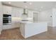 Bright kitchen featuring white cabinets, a center island, stainless steel appliances, and stylish backsplash at 18432 W Mohave St, Goodyear, AZ 85338