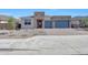 Stunning single-story home featuring a paver driveway, blue garage doors, and minimalist desert landscaping at 18444 W Mohave St, Goodyear, AZ 85338