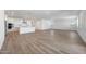 Open-concept living space with wood-look tile, adjacent to a modern kitchen with an island at 18444 W Mohave St, Goodyear, AZ 85338