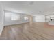 Spacious open-concept living space with wood-look tile and natural light from sliding glass doors at 18444 W Mohave St, Goodyear, AZ 85338