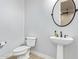 Powder room featuring pedestal sink, round mirror, and tiled floors at 19318 E Walnut Rd, Queen Creek, AZ 85142