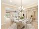 Cozy dining room features a decorative chandelier, neutral paint, tile floors, and open view to the living room at 19318 E Walnut Rd, Queen Creek, AZ 85142