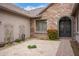 Arched stone entryway with custom iron door, decorative plants, and travertine tile at 19318 E Walnut Rd, Queen Creek, AZ 85142