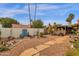 Picturesque backyard featuring desert landscaping, a covered patio area, and a unique blue door, creating a tranquil outdoor space at 1975 E Sunburst Ln, Tempe, AZ 85284