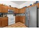 Functional kitchen with stainless steel appliances, wood cabinets, and tile backsplash at 1975 E Sunburst Ln, Tempe, AZ 85284