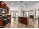 Modern kitchen with a center island and stainless steel appliances seamlessly flowing into the living spaces at 20212 N Valencia Dr, Maricopa, AZ 85138