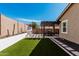 Backyard with a pergola-covered patio, fireplace, artificial turf, and desert landscaping at 20524 W Nelson Pl, Buckeye, AZ 85396