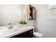 Powder room featuring a cabinet with a sliding door and a decorative plant on the white countertop at 20524 W Nelson Pl, Buckeye, AZ 85396