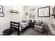 Inviting bedroom featuring a striped bed, cozy armchair, and natural light from shuttered windows at 20524 W Nelson Pl, Buckeye, AZ 85396