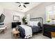 Cozy bedroom featuring neutral walls, a black metal bed frame, and natural light from shuttered windows at 20524 W Nelson Pl, Buckeye, AZ 85396