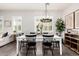 Bright dining room featuring a chandelier, white table with black chairs, and ample natural light at 20524 W Nelson Pl, Buckeye, AZ 85396