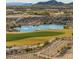 Picturesque golf course view with a tranquil pond and stunning mountain backdrop at 20524 W Nelson Pl, Buckeye, AZ 85396