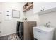 Functional laundry room with modern appliances, storage shelves, and a sink at 20524 W Nelson Pl, Buckeye, AZ 85396