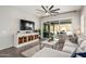 Bright living room featuring a large sectional, modern console, and sliding glass doors to the outdoor space at 20524 W Nelson Pl, Buckeye, AZ 85396