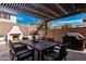 Outdoor dining area with a fireplace, patio seating, string lights, and a built-in grill at 20524 W Nelson Pl, Buckeye, AZ 85396