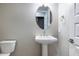 Powder room with pedestal sink, oval mirror, toilet and light gray walls at 21323 N 61St St, Phoenix, AZ 85054