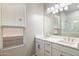 Bathroom featuring double sinks, a large mirror, white cabinets, and a window that provides ample natural light at 21323 N 61St St, Phoenix, AZ 85054