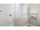 Bathroom view highlighting the frameless shower with a marble tile surround, a shower head, and a window at 21323 N 61St St, Phoenix, AZ 85054