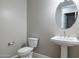 Powder room features a toilet and pedestal sink with a mirror and light gray walls at 21323 N 61St St, Phoenix, AZ 85054