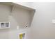 Functional laundry room with shelf, hookups, outlets, and painted gray walls at 21323 N 61St St, Phoenix, AZ 85054