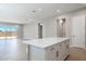 Bright open-concept living area with wood-look tile flooring, sliding glass doors, and a kitchen island at 21323 N 61St St, Phoenix, AZ 85054