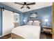 Blue bedroom featuring a sliding door leading to the on-suite bathroom and a modern ceiling fan at 2201 N 17Th Ave, Phoenix, AZ 85007