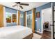 Blue bedroom showcasing two windows with golden curtains, a ceiling fan and wood floors at 2201 N 17Th Ave, Phoenix, AZ 85007