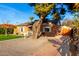 Quaint brick home showcasing a beautifully landscaped front yard with mature trees and manicured gravel area at 2201 N 17Th Ave, Phoenix, AZ 85007