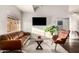 Stylish living room featuring a leather sofa, modern chair, and a large window with natural light at 2201 N 17Th Ave, Phoenix, AZ 85007