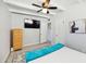 Bright bedroom features a TV, ceiling fan, and white-painted ceiling beams above neutral-toned flooring at 2205 W Cambridge Ave, Phoenix, AZ 85009