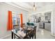 Open concept dining room with table, chairs, orange curtains, and view into the bright kitchen at 2205 W Cambridge Ave, Phoenix, AZ 85009