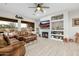 Cozy living room showcasing a fireplace with tile detail, built-in shelving, and a ceiling fan at 22222 N 54Th Way, Phoenix, AZ 85054