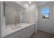 Bathroom featuring a double vanity, white cabinets, and large mirror at 24192 W Agora Ln, Buckeye, AZ 85326
