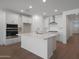Bright, open kitchen featuring sleek white cabinetry and stainless steel appliances at 24192 W Agora Ln, Buckeye, AZ 85326