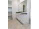 Bathroom featuring tiled floors, a double vanity with granite counters, and a large framed mirror at 24478 N 166Th Ave, Surprise, AZ 85387