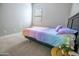 Bedroom with window, neutral carpet, color gradient cover, and side table at 24478 N 166Th Ave, Surprise, AZ 85387