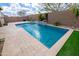 Sparkling pool with water feature complemented by a travertine tile deck and lush landscaping at 24478 N 166Th Ave, Surprise, AZ 85387