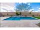 Inviting pool showcases a water feature, travertine tile surround, and low-maintenance artificial turf at 24478 N 166Th Ave, Surprise, AZ 85387